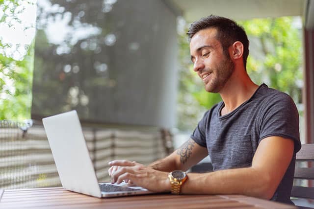 a man looking into the laptop studying for exam